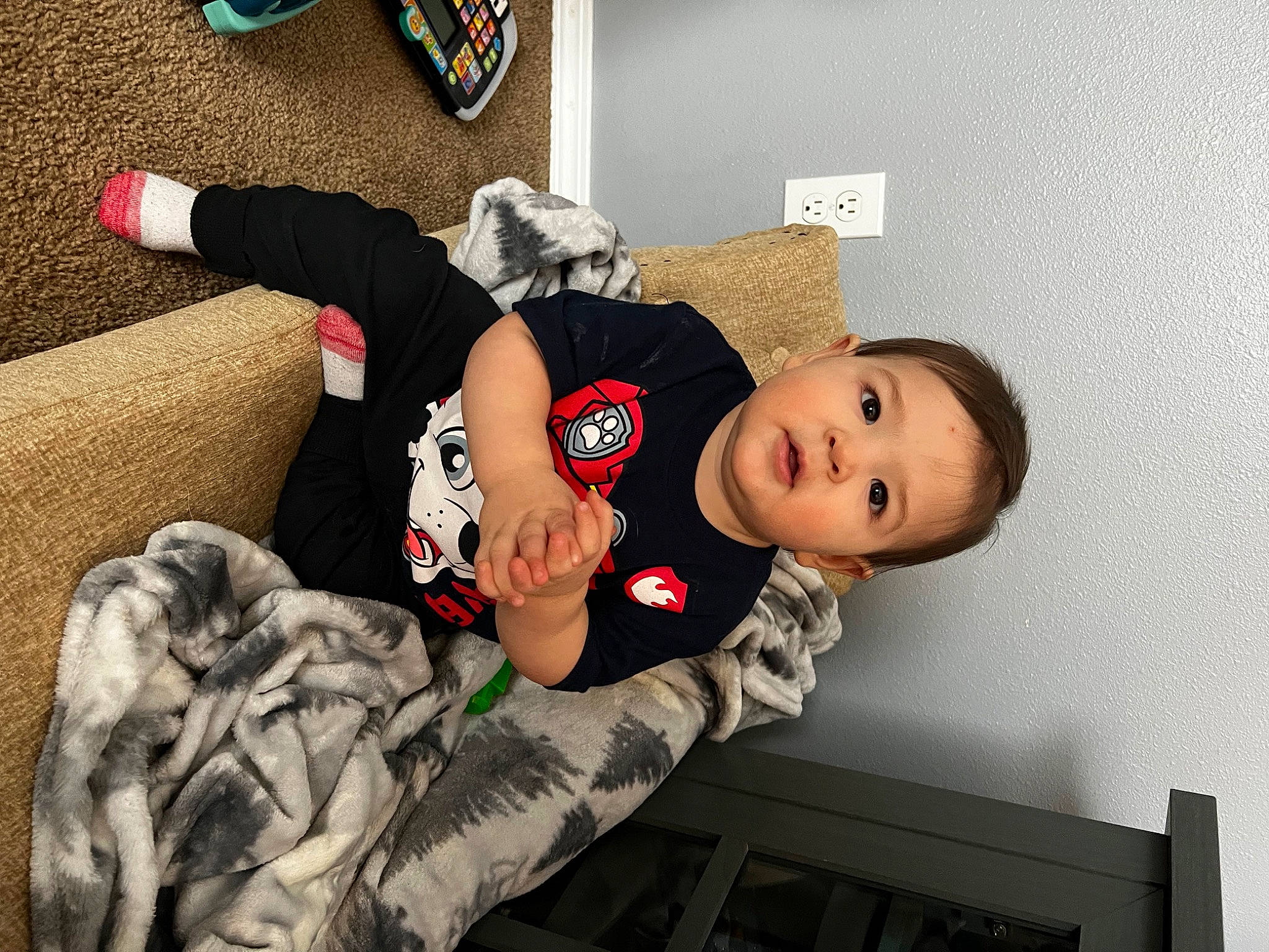 Kaiden is registered to the contest to win money with this photo: baby, baby_products, baby_toddler_clothing, carmine, child, comfort, couch, fun, happy, hat, human_leg, leg, person, room, sitting, sleeve, smile, sock, thigh, toddler