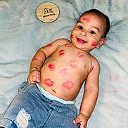 Noah is registered to the contest to win money with this photo: baby, infant, six_months, kiss_marks, smiling, face, arm, hand, bracelet, denim_shorts, ripped_shorts, diaper, blanket, wooden_marker, milestone, happy, cute, lying_down, skin, portrait