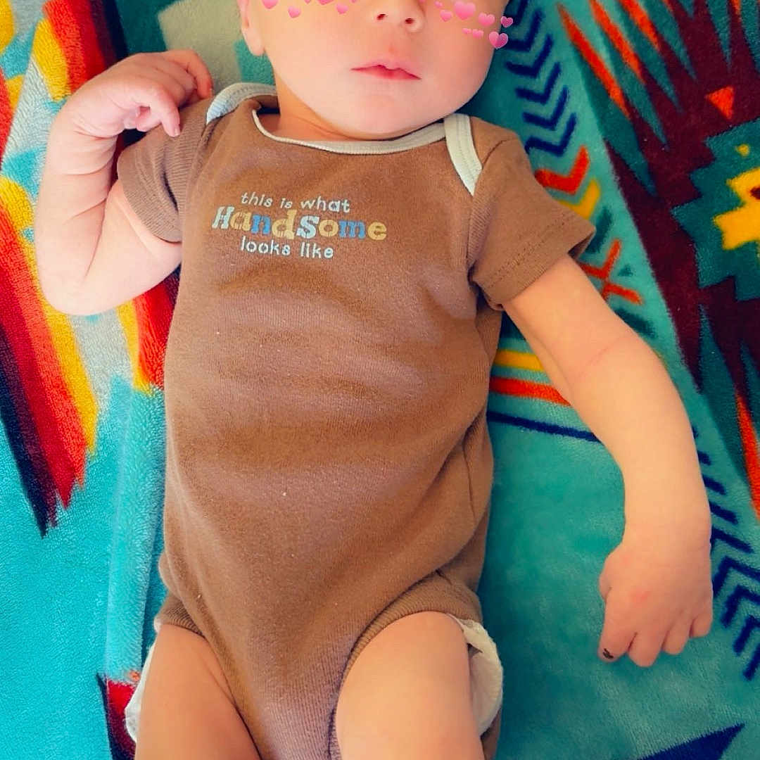 Dawsonn Blake is registered to the contest to win money with this photo: adorable, arms, baby, blanket, child, clothing, cute, face, filter, head, human, indoors, infant, legs, lying_down, onesie, patterned_blanket, pink_hearts, skin, small_baby