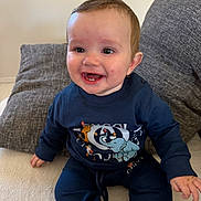Manoë participe au concours pour gagner de l'argent avec cette photo : baby, child, closeup, couch, elephant_graphic, eyes, fabric, hair, hand, happy, indoor, infant, navy_clothing, pillow, portrait, rosy_cheeks, sitting, smile, sweatshirt, teeth