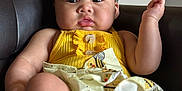Delilah joined the competition — help win amazing prizes! baby, child, yellow_dress, sitting, leather_chair, indoor, curious_expression, skin, face, arms, legs, buttoned_clothing, patterned_skirt, black_hair, infant, portrait, young_child, furniture, cute, person