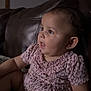 baby, child, infant, leopard_print, pink_dress, sitting, couch, leather, indoor, portrait, curious, side_view, soft_light, expression, young_child, toddler, short_hair, home, comfortable, furniture