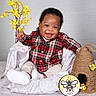 baby, child, smile, plaid_shirt, beige_pants, white_shoes, yellow_flowers, bee, beehive, decor, soft_blanket, chair, indoor, cute, happy, portrait, person, sitting, cozy, background