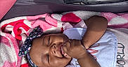 Levyn joined the competition — help win amazing prizes! baby, bib, blanket, child, clothing, cozy, cute, face, hands, happy, headband, infant, lying_down, outdoor, person, skin, smile, stroller, sunlight, toddler