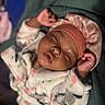 baby, sleeping, blanket, headband, pink, floral, soft, child, peaceful, closeup, face, resting, cozy, infant, hands, cute, portrait, warm_lighting, fabric, relaxation