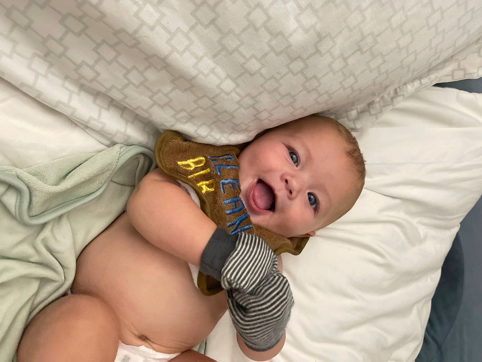 Kane is registered to the contest to win money with this photo: abdomen, baby, baby_products, baby_safety, baby_toddler_clothing, chest, comfort, couch, eye, foot, happy, human_body, human_leg, knee, linens, person, sitting, smile, textile, thigh