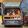 Nora is registered to the contest to win money with this photo: child, baby, van, camper_van, vintage_van, bicycle, bike, dog_portrait, dogs, museum, exhibit, display, license_plate, indoor, people, jacket, blanket, storage_compartment, open_hatch, portrait