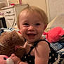 toddler, child, smiling, stuffed_animal, plush_toy, bed, blanket, pillow, indoor, happy, cute, baby, clothing, person, furniture, home, soft_toy, joyful, skin, face