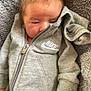 Alfie joined the competition — help win amazing prizes! newborn, baby, infant, grey_clothing, nike, onesie, blanket, soft_texture, hand, fist, sleepy, cute, cozy, indoors, portrait, child, face, hair, zipper, fabric