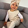 Inaya a rejoint le concours — aidez-le/la à gagner de superbes lots ! toddler, child, baby, smiling, sitting, couch, knitted_hat, bow, cream_clothing, long_sleeve_shirt, pants, socks, face, happy, indoors, furniture, portrait, cute, young_child, cozy