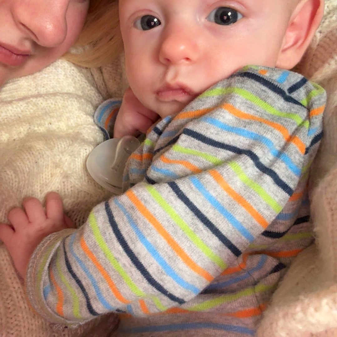 Grayson is registered to the contest to win money with this photo: baby, bond, child, closeup, comfort, cuddle, expression, face, family, hand, indoor, infant, knit_sweater, person, portrait, skin, soft_lighting, striped_sweater, warmth, young_child