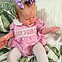 Marliya-Mae joined the competition — help win amazing prizes! baby, child, girl, pink_dress, purple_bows, hair_bows, tights, cushion, leaf_pattern, bed, pillow, holding_hand, indoor, cute, infant, sitting, portrait, clothing, person, headwear
