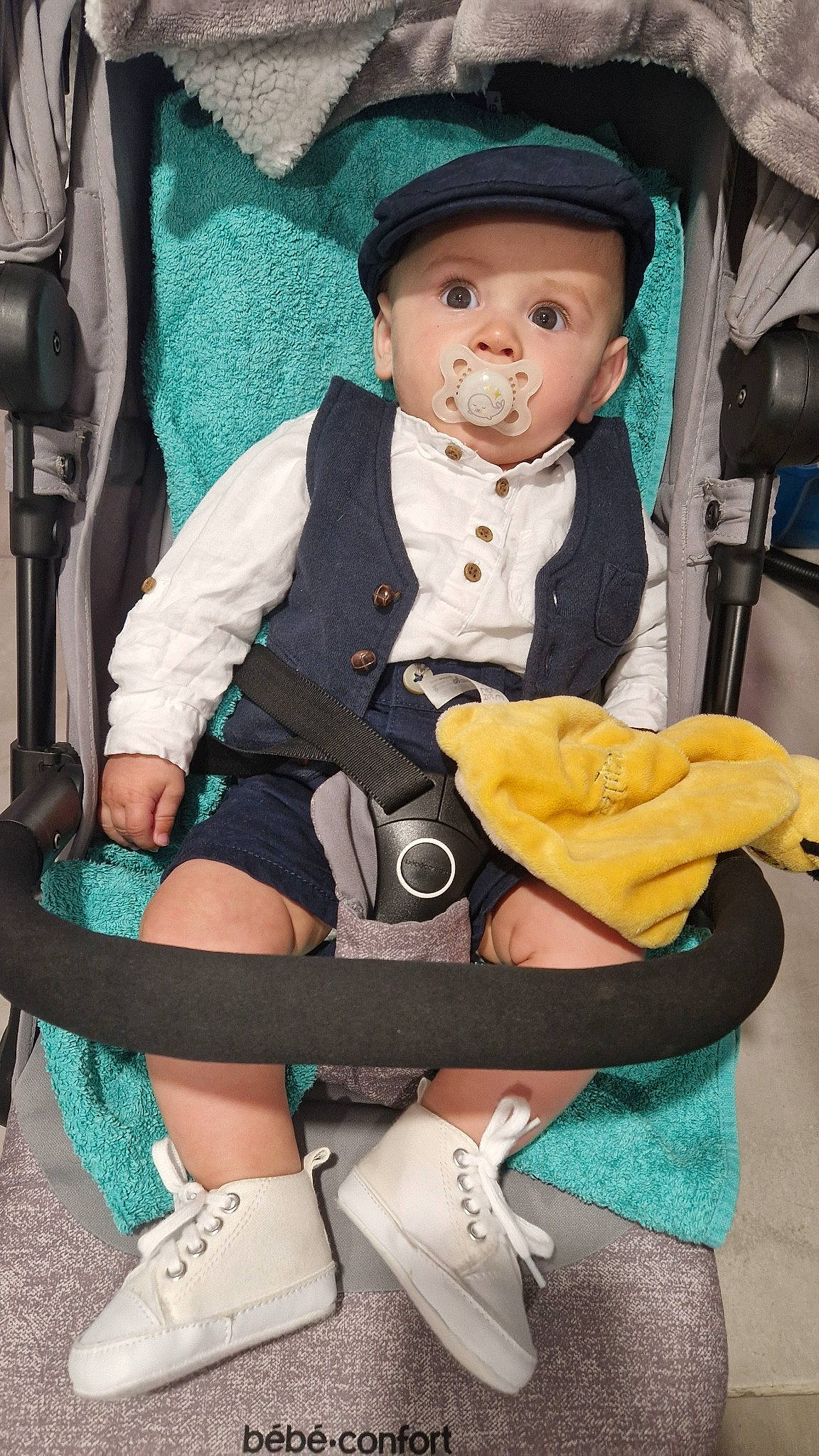 Alyssio participe au concours pour gagner de l'argent avec cette photo : arm, baby, baby_carriage, baby_products, baby_toddler_clothing, bag, chair, child, comfort, hat, headgear, headwear, human_leg, knee, lap, person, sitting, sleeve, sock, sun_hat