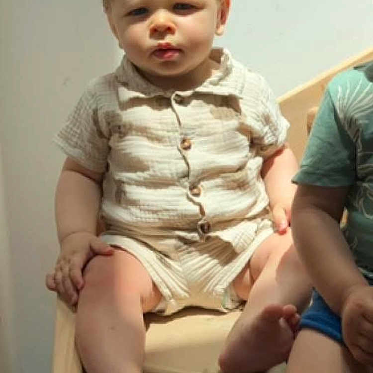 Ambrossio a rejoint le concours — aidez-le/la à gagner de superbes lots ! barefoot, beige_clothing, casual_wear, child, face, furniture, hair, indoor, light_shadows, natural_light, person, serious_expression, short_sleeves, shorts, sitting, skin, toddler, two_children, wooden_bench, young