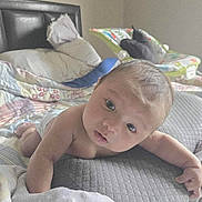 Loretto is registered to the contest to win money with this photo: baby, infant, bed, pillow, blanket, diaper, baby_rocker, indoor, child, person, face, curious, soft_light, skin, head, arms, hand, room, furniture, resting