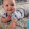 baby, infant, smile, face, hand, carpet, floor, mickey_mouse, clothing, toddler, cute, indoor, baby_gate, playful, happy, person, skin, head, lying, expression