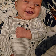 Cory is registered to the contest to win money with this photo: baby, blanket, cat_pattern, child, cozy, cute, dog_print, face, hand, happy, indoors, infant, lying_down, onesie, portrait, sleepwear, smiling, soft_texture, striped_clothing, warm