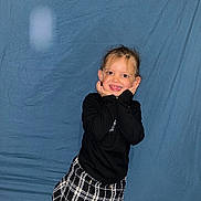 Celeste participe au concours pour gagner de l'argent avec cette photo : child, smiling_child, girl, portrait, blue_backdrop, wrinkled_sheet, black_top, checkered_skirt, posing, hands_on_cheeks, happy, tooth_gap, flash, indoor, studio_style, candid, playful, single_person, fashionable, young_child
