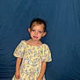 Celeste participe au concours pour gagner de l'argent avec cette photo : child, girl, toddler, floral_dress, yellow_dress, blue_backdrop, portrait, smile, brown_hair, big_eyes, puffy_sleeves, standing, ears, hands, studio_style, candid, front_flash, fabric, innocence, cute