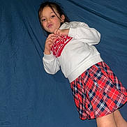 Kayla participe au concours pour gagner de l'argent avec cette photo : child, girl, portrait, lying_down, blue_sheet, sweatshirt, plaid_skirt, red, white, casual_clothing, long_hair, pout, hands, face, legs, indoor, bed, flash_photo, playful, young_child