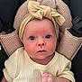 baby, infant, child, headband, bow, car_seat, clothing, cream_color, fist, face, wide_eyes, portrait, seated, looking_at_camera, indoor, padded, knitted, newborn, cute, serious_expression