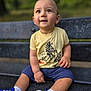 toddler, child, bench, outdoor, smiling, yellow_tshirt, blue_shoes, shorts, nature, park, happy, sitting, cute, face, person, footwear, casual_clothing, daylight, expression, young_child