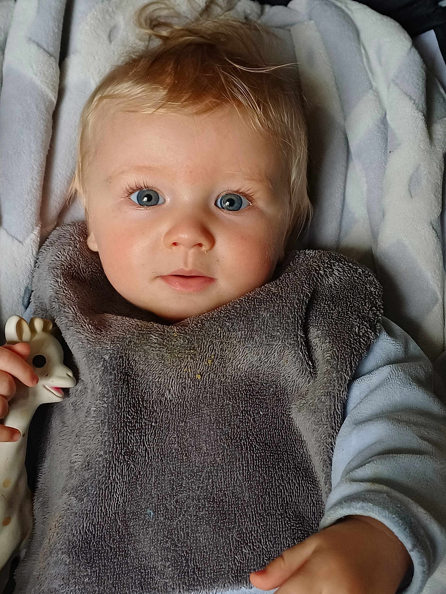 Tahys participe au concours pour gagner de l'argent avec cette photo : baby, blue_eyes, bib, blanket, child, close_up, cute, face, giraffe_toy, hand, infant, laying, light, looking_at_camera, person, plush, portrait, soft_texture, toy, young_child