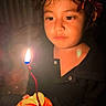 Jasmine Kaur is registered to the contest to win money with this photo: child, toddler, birthday, cake, candle, candlelight, crown, devil_horns, portrait, face, eyes, hair, black_clothing, dessert, strawberry, fruit, hands, indoor, dark_background, celebration