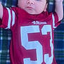 baby, infant, child, red_jersey, 49ers, plaid_blanket, lying_down, raised_arm, casual, outdoor, soft_light, face, portrait, young_child, cute, resting, clothing, sportswear, hand, skin