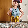 Jaylee joined the competition — help win amazing prizes! backpack_strap, bedspread, cap, carpeted_floor, casual, child, colorful_clothing, dress, earrings, floral_pattern, girl, happy, indoors, playful, portrait, pose, room_interior, smiling, wall_art, wooden_door