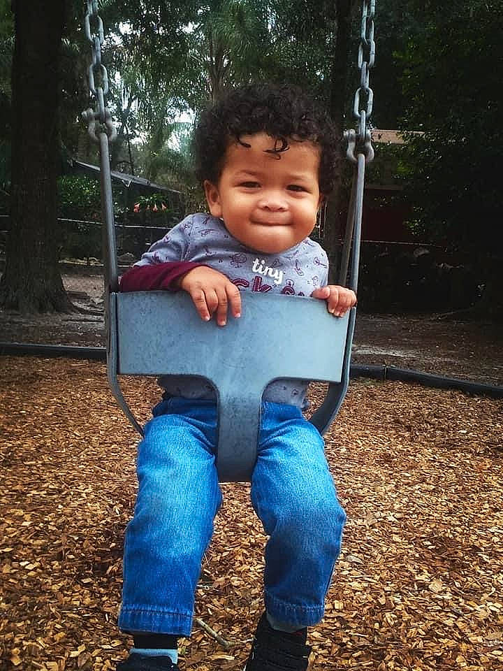Moaniel is registered to the contest to win money with this photo: child, denim, jeans, joy, outdoor_play_equipment, person, play, playground, recreation, smile, swing, toddler, tree