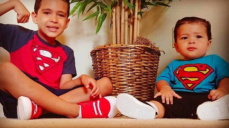 Moaniel is registered to the contest to win money with this photo: baby, child, fictional_character, furniture, happy, joy, justice_league, leisure, love, person, play, sibling, superhero, superman, toddler, vacation, wicker