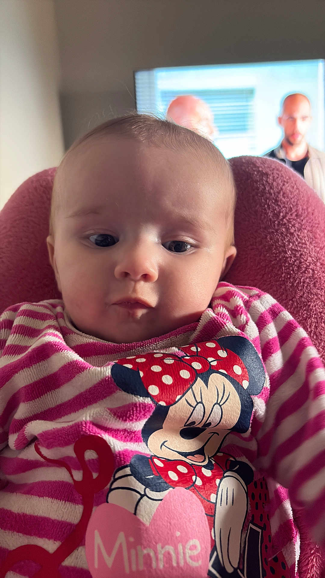 Aliyah participe au concours pour gagner de l'argent avec cette photo : baby, infant, child, face, eyes, cheeks, minnie_mouse, cartoon, striped_clothing, pink, onesie, seat, blanket, indoor, portrait, close_up, television, adults_in_background, candid, cute