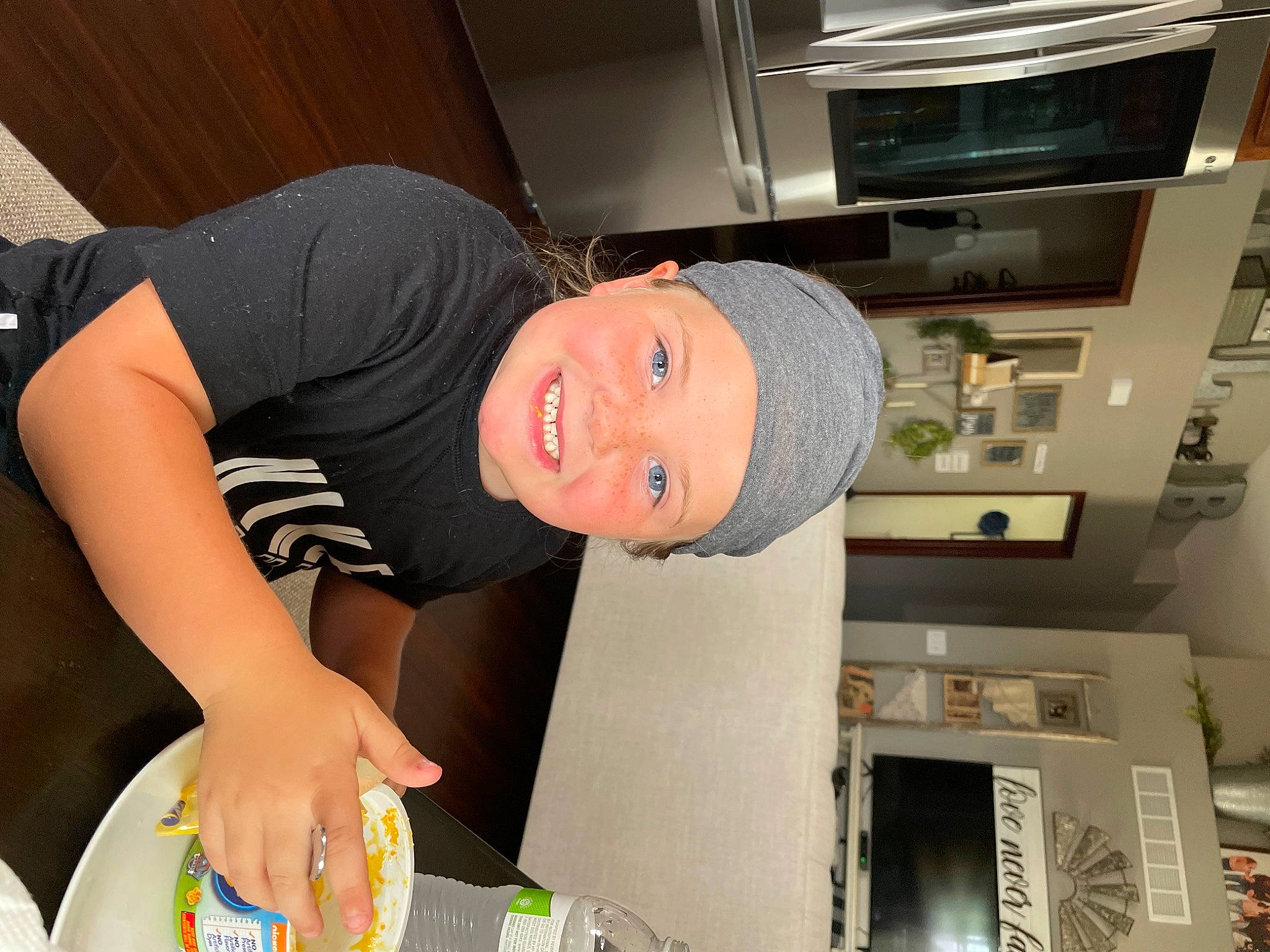 Beckett is registered to the contest to win money with this photo: baseball_cap, cap, child, comfort, elbow, fun, happy, hat, headwear, joy, knee, machine, person, room, sleeve, smile, t_shirt, thigh, wrist