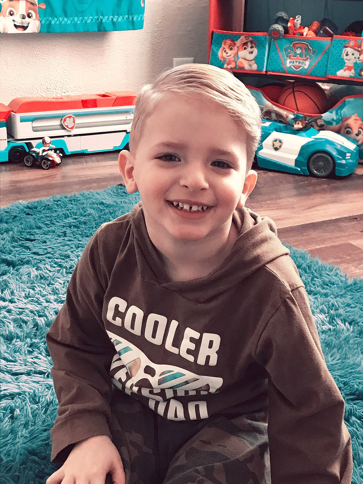 Rylan is registered to the contest to win money with this photo: automotive_tire, blue, child, cool, facial_expression, grass, hairstyle, happy, joy, land_vehicle, leisure, motor_vehicle, person, plant, public_space, sleeve, smile, t_shirt, tire, toddler