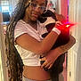 indoor, woman, cat, hugging, affection, glasses, long_hair, white_shirt, gray_pants, black_and_white_cat, tattoo, door, home, love, pet, casual_clothing, relaxed, comfort, human, animal