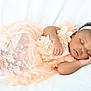 baby, sleeping, peach_dress, lace, headband, infant, soft_blanket, peaceful, cute, portrait, newborn, child, resting, indoors, adorable, toddler, sleep, closeup, delicate, calm