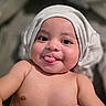 baby, infant, tongue_out, cute, smile, hat, headwear, skin, bare_chest, closeup, portrait, child, happy, playful, indoors, soft_light, expression, face, young, human