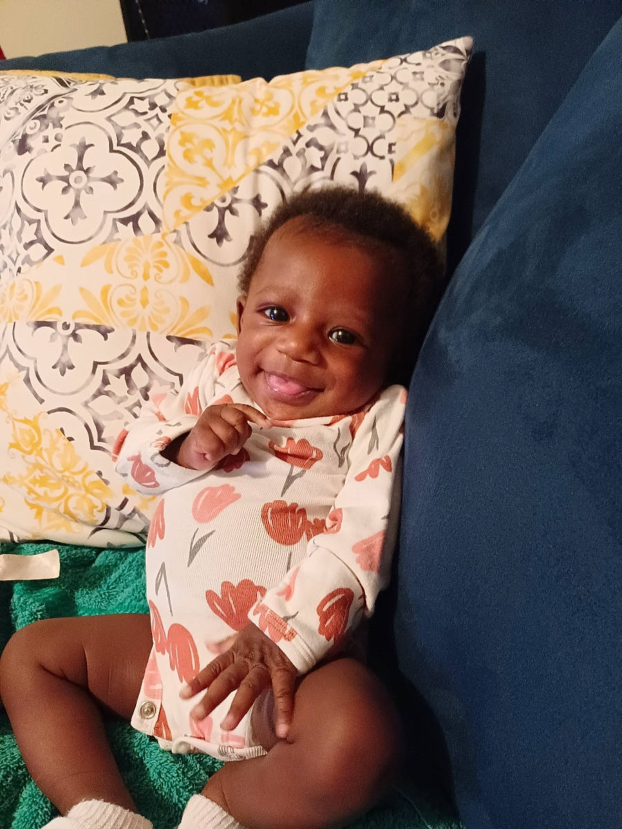 Starr joined the competition — help win amazing prizes! child, comfort, cool, dress, facial_expression, finger, fun, hairstyle, happy, human_leg, joy, linens, pattern, person, pillow, room, sitting, skin, smile, textile