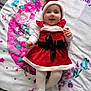 baby, smiling, red_dress, white_tights, santa_hat, blanket, floral_pattern, butterflies, lying_down, happy, infant, holiday, festive, cute, child, portrait, clothing, soft_texture, fabric, indoor