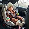 baby_boots, boots, brown_outfit, car_door, car_interior, car_seat, child, child_safety, fogged_window, hat, infant, knit_hat, person, plastic_toys, seat, seatbelt, toddler, toy, window, winter_clothing