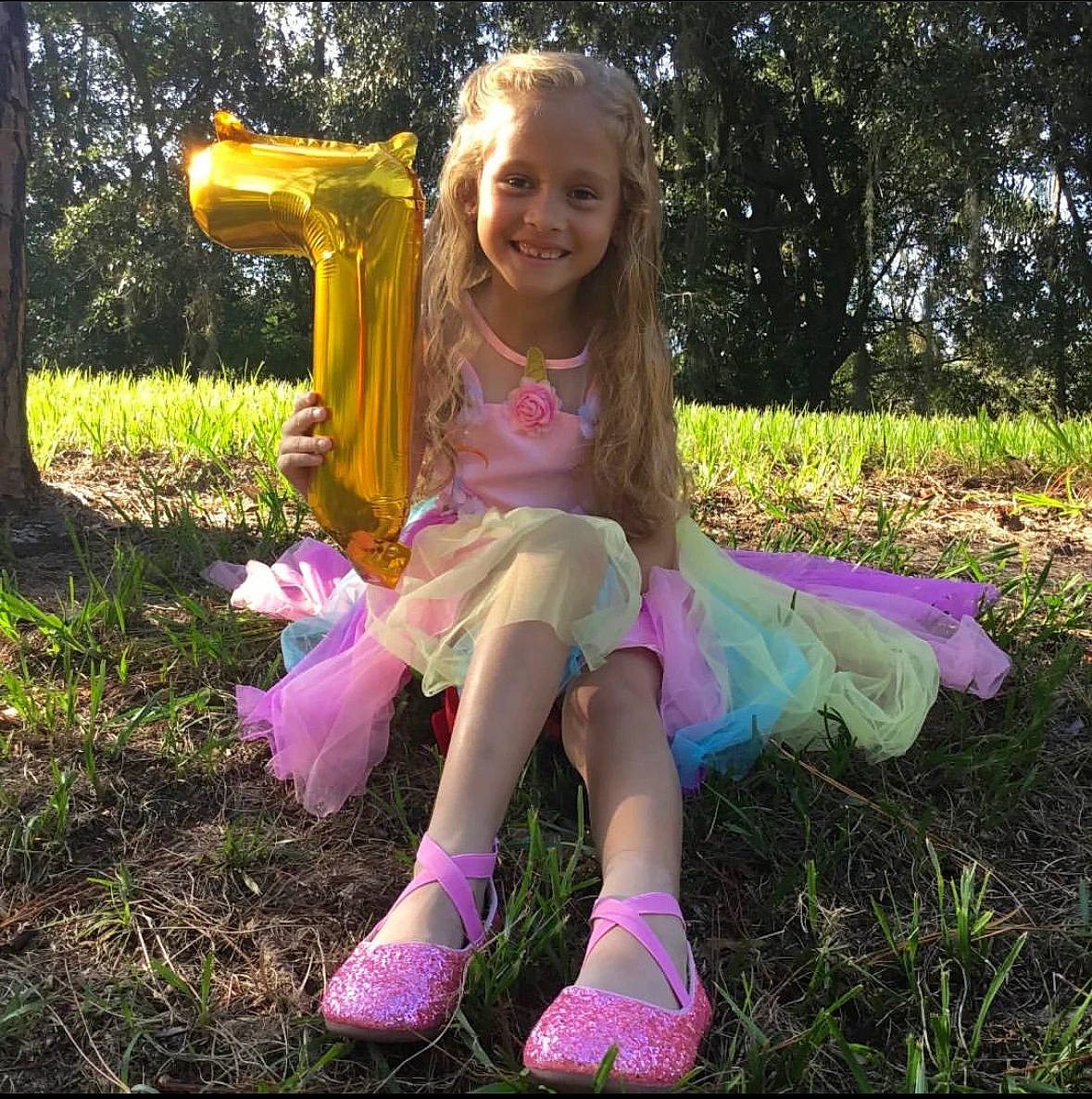 Alice is registered to the contest to win money with this photo: dress, face, fawn, grass, grass_family, hair, happy, head, joy, meadow, natural_environment, people_in_nature, person, pink, plant, purple, shoe, smile, sneakers, terrestrial_plant