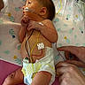 newborn, baby, infant, diaper, medical_wires, hospital, blanket, hand, skin, monitoring, cute, child, person, lying_down, healthcare, baby_care, tender, floral_pattern, bed, resting
