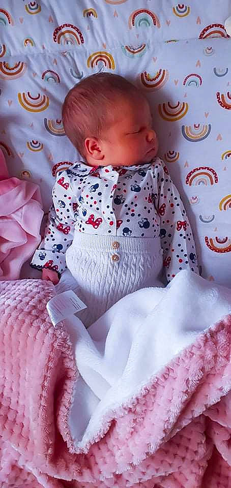 Cristina a rejoint le concours — aidez-le/la à gagner de superbes lots ! baby, baby_products, baby_toddler_clothing, bedding, cheek, child, comfort, embellishment, face, linens, magenta, pattern, person, pink, purple, room, sitting, skin, sleeve, textile