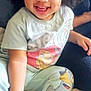 Wynter is registered to the contest to win money with this photo: toddler, child, smiling, laughing, afro_hair, pajamas, cartoon_print, bed, blanket, indoor, happy, cute, person, skin, hand, foot, cozy, soft_lighting, portrait, casual