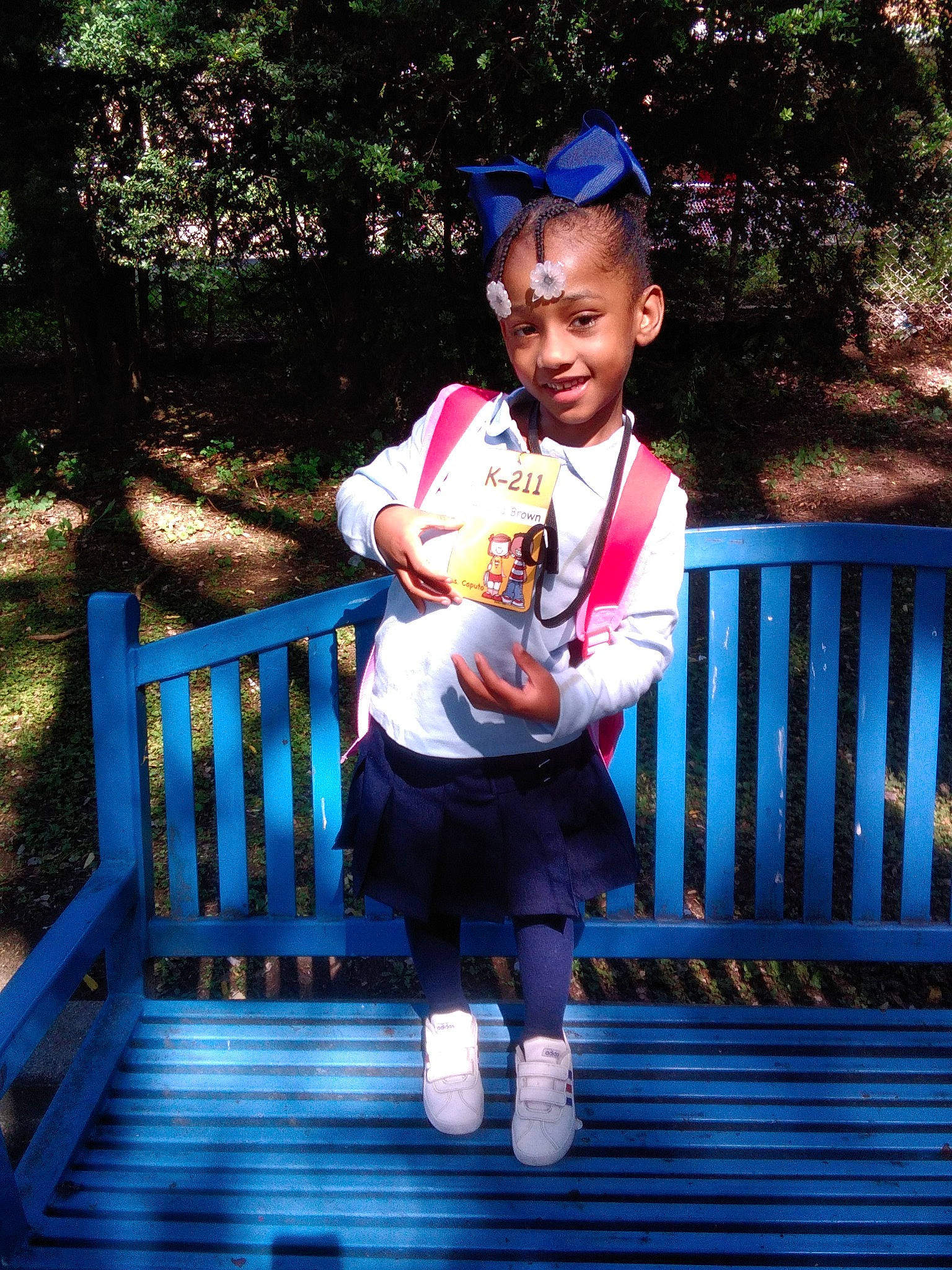 Avianna is registered to the contest to win money with this photo: blue, child, deck, electric_blue, fence, fun, grass, happy, joy, leisure, person, plant, recreation, shorts, sitting, smile, sun_hat, t_shirt, toddler, tree