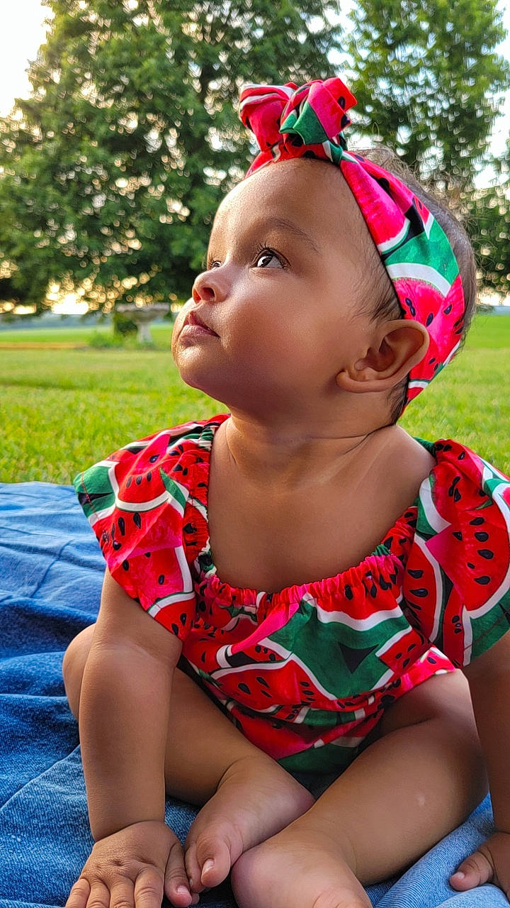 Kylee joined the competition — help win amazing prizes! baby_toddler_clothing, chin, clothing, cool, facial_expression, grass, green, hairstyle, happy, leaf, leisure, lip, neck, person, pink, red, shoulder, skin, thigh, toddler