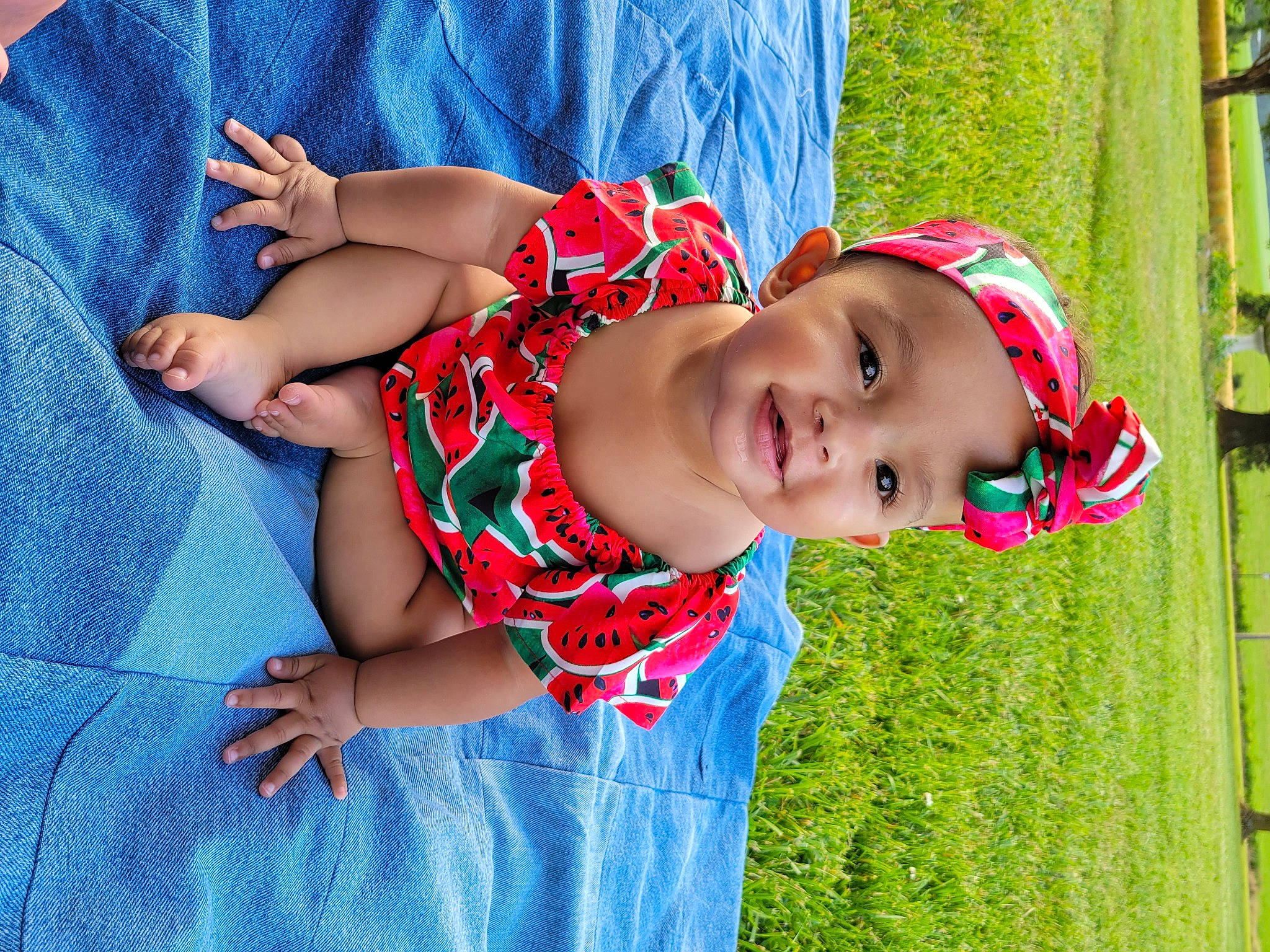 Kylee is registered to the contest to win money with this photo: baby, baby_toddler_clothing, blue, child, electric_blue, fun, grass, happy, hat, headwear, leaf, leisure, pattern, people, people_in_nature, person, plant, play, recreation, smile