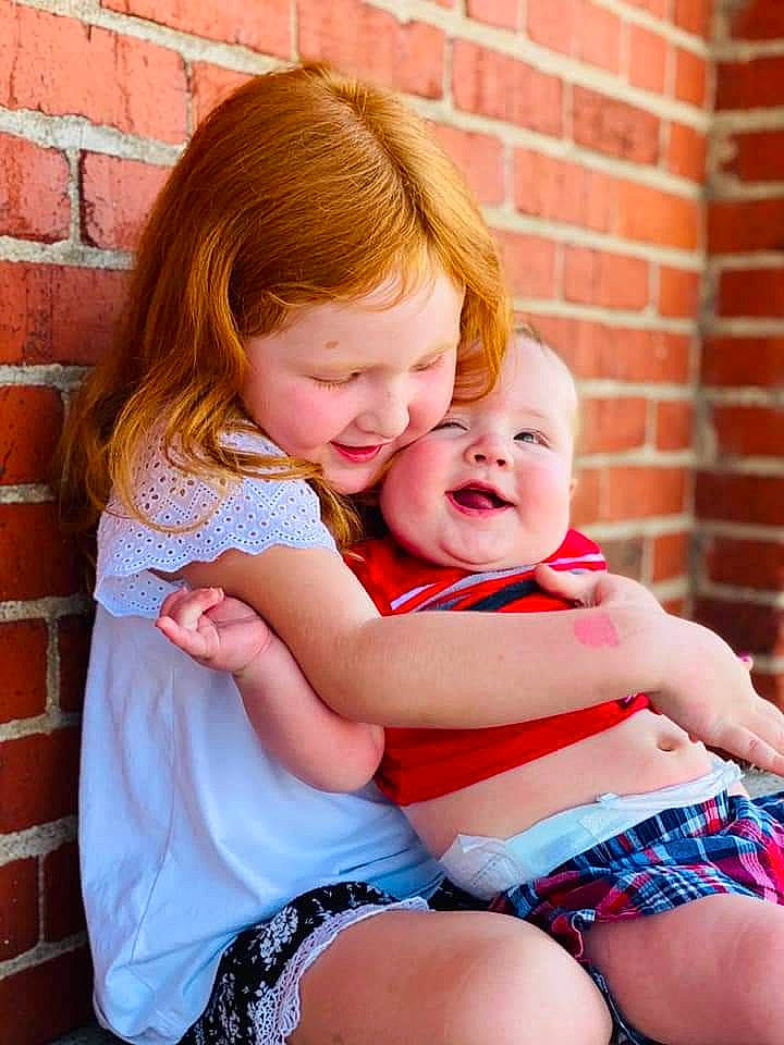 Granger is registered to the contest to win money with this photo: abdomen, baby, child, finger, happy, hug, interaction, joy, pattern, person, plaid, sitting, toddler, trunk
