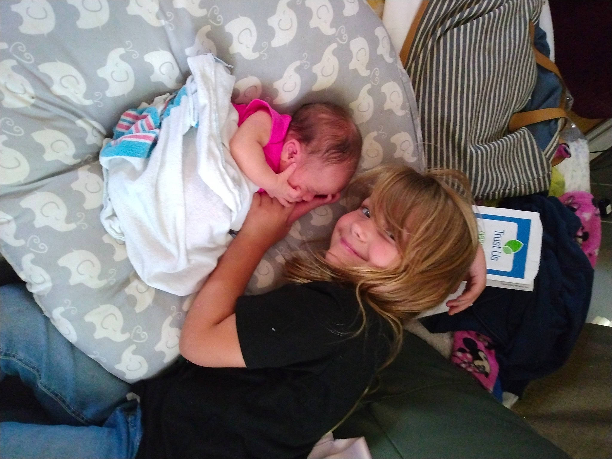 Blair is registered to the contest to win money with this photo: baby, baby_products, baby_toddler_clothing, blond, child, comfort, couch, event, fun, happy, joy, lap, leisure, pattern, person, room, sitting, smile, t_shirt, toddler